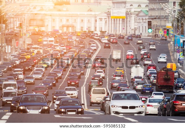 View from above to the heavy traffic on the city\
highway with warm sunlight