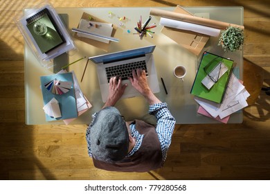 View From Above. Man Sitting At His Desk And Typing On A Laptop