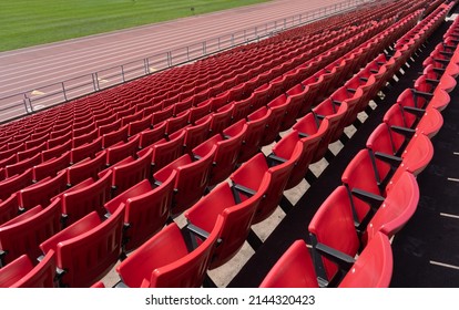 View From Above Of Many Rows Of Red Seats And Track At An Outdoor Stadium