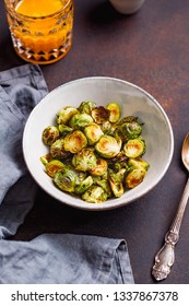 View From Above On A Ceramic Bowl With Roasted Brussel Sprouts On A Table. The Concept Of Healthy Vegetarian Eating.