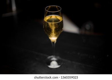 View From Above On The Cocktail With Champagne And A Sugar Cube In The Glass On The Bar Counter In The Dark Blurred Background