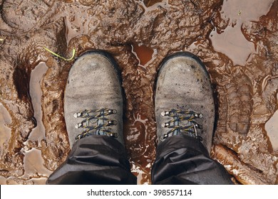View from above on pair of trekking shoes in a mud