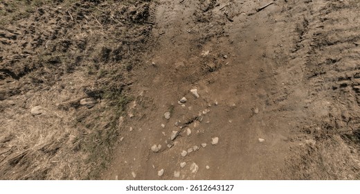 view from above on surface of texture of dry road with tractor tire tracks in countryside
