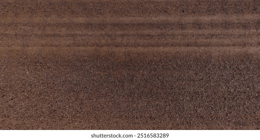 view from above on texture of dry road with tractor tire tracks in countryside