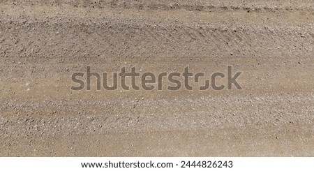view from above on texture of gravel road with car tire tracks