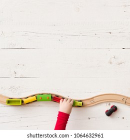 View From Above On Toy Wooden Trains On Railway. Child's Hands Playing With Educational Toy - Train