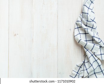 View from above on white wooden table with linen kitchen towel or textile napkin. Blue tablecloth on white wood tabletop. Copy space for text. Can use as mock up for design.
