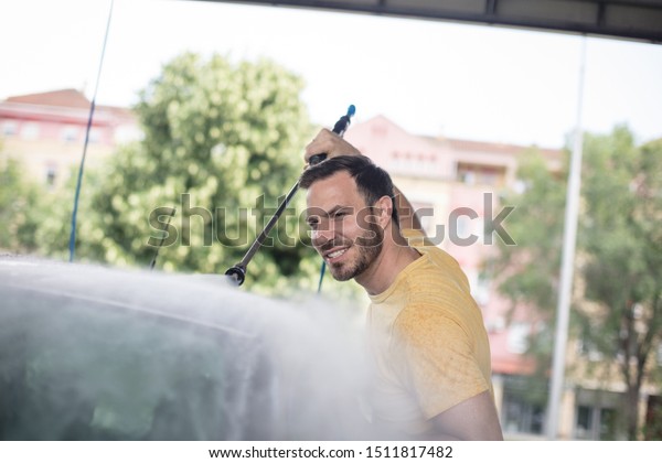 The view\
from above is perfect. Man washing\
car.