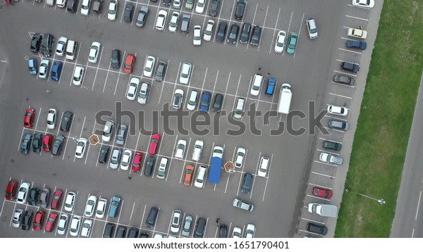 A\
view from above to the process of car parking. Heavy traffic in the\
parking lot. Searching for spaces in the busy car park. Parking\
advice. Cruising for parking in busy business\
center