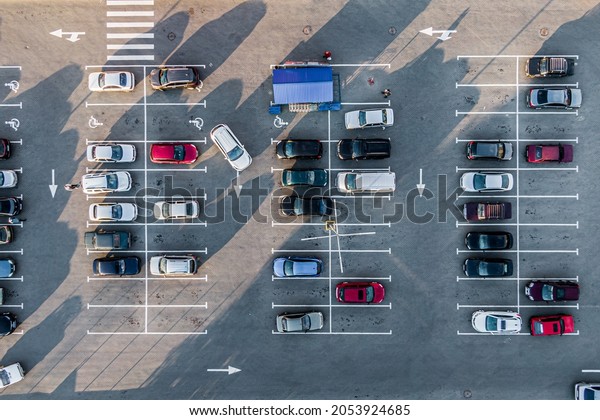 A\
view from above to the process of car parking. Heavy traffic in the\
parking lot. Searching for spaces in the busy car park. Parking\
advice. Cruising for parking in busy business\
center.