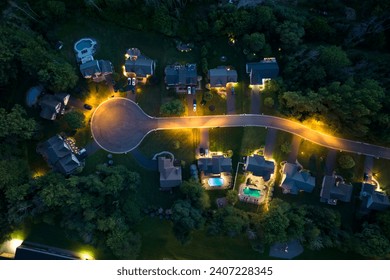 View from above of residential houses in living area in Rochester, NY at night. Illuminated american dream homes as example of real estate development in US suburbs