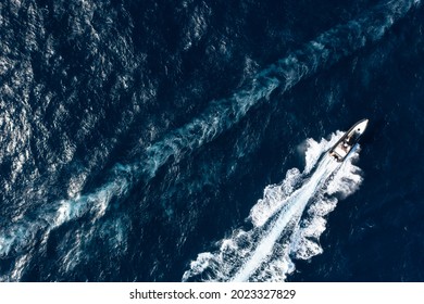 View From Above, Stunning Aerial View Of A Boat Cruising On A Blue Water Creating A Wake. Costa Smeralda, Sardinia, Italy.