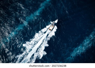 View From Above, Stunning Aerial View Of A Boat Cruising On A Blue Water Creating A Wake. Costa Smeralda, Sardinia, Italy.