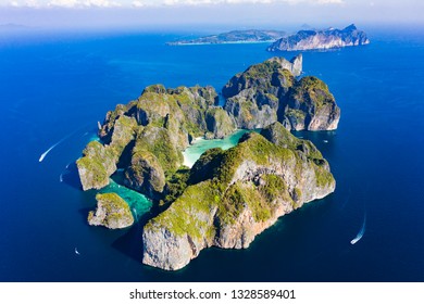 View from above, stunning aerial view of Koh Phi Phi Lee with the beautiful beach of Maya Bay bathed by a turquoise clear water. Amazing limestone karst formations surround this island in Thailand.