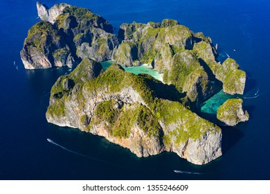 View from above, stunning aerial view of Koh Phi Phi Leh (Phi Phi Island) with the beautiful Maya Bay. A turquoise and clear water bathes a white beach surrounded by limestone mountain.