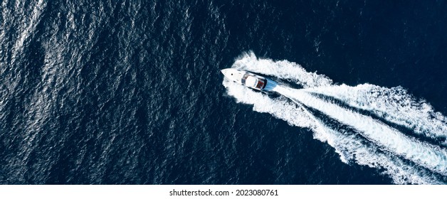 View from above, stunning aerial view of a luxury yacht cruising on a blue water creating a wake. Costa Smeralda, Sardinia, Italy. - Powered by Shutterstock