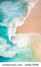 View From Above, Stunning Aerial View Of A Person Walking On A Beautiful Beach Bathed By A Turquoise Sea During Sunset. Kelingking Beach, Nusa Penida, Indonesia.