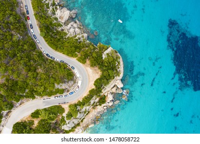 View From Above, Stunning Aerial View Of A Road That Runs Along A Rocky Coast Bathed By A Turquoise And Transparent Sea. Cala Gonone, Sardinia, Italy.