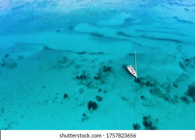 View from above, stunning aerial view of a sailing boat floating on a beautiful turquoise sea. Porto Cervo, Costa Smeralda, Sardinia, Italy. 