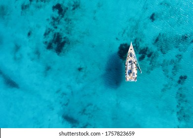 View from above, stunning aerial view of a sailing boat floating on a beautiful turquoise sea. Porto Cervo, Costa Smeralda, Sardinia, Italy. 
