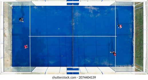 View From Above, Stunning Aerial View Of Some People Playing On A Blue Padel Court. Padel Is A Mix Between Tennis And Squash. It's Usually Played In Doubles On An Enclosed Court.