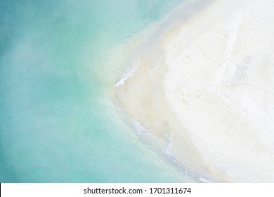 View from above, stunning aerial view of a white sand beach bathed by a beautiful turquoise sea. Tanjung Aan Beach, east of Kuta Lombok, West Nusa Tenggara, Indonesia.