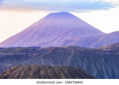 View from above, stunning view of the Mount Batok in the foreground and the Mount Semeru in the distance illuminated at sunrise, East Java, Indonesia.