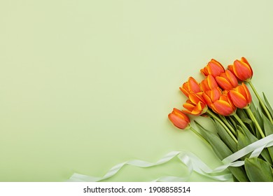 View from above tulip flowers orange color with copy space on green. Background for womens day, 8 March Valentines day, 14 february. Flat lay style, top view, mockup, template, overhead. Greeting card