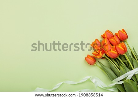 View from above tulip flowers orange color with copy space on green. Background for womens day, 8 March Valentines day, 14 february. Flat lay style, top view, mockup, template, overhead. Greeting card