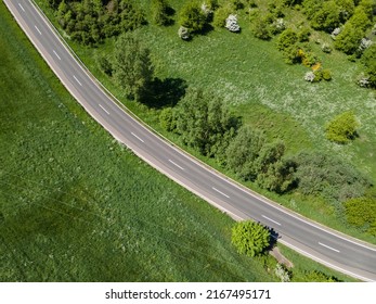 View From Above Of A Winding Country Road Between Grass Fields On A Sunny Day In Spring