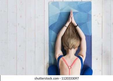 View From Above Of Young Woman Working Out At Home On White Wooden Floor, Doing Yoga Exercise On Blue Mat, Relaxing And Meditating After Practice