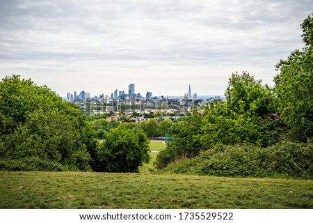 A view across the fields and trees to the City of London from the Parliament Hill Viewpoint in Hampstead Heath, London