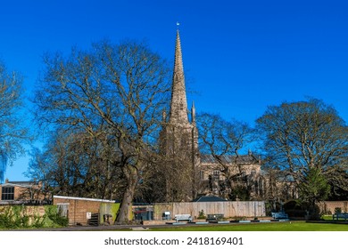 A view across gardens towards the Saint Mary and Saint Nicolas Church in Spalding, Lincolnshire on a bright sunny day