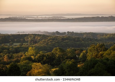 View across the Kent Weald at sunrise with layers of mist in soft autumn light - Shutterstock ID 1544696348