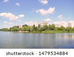 View across the lake to the houses in the city. Landscape outside the city