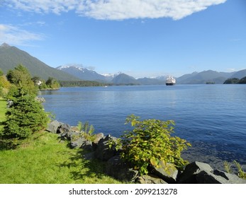  A View Across The Lake At Sitka, Alaska In Summer, With A Cruise Ship And Snow-covered Mountains In The Distance.                    