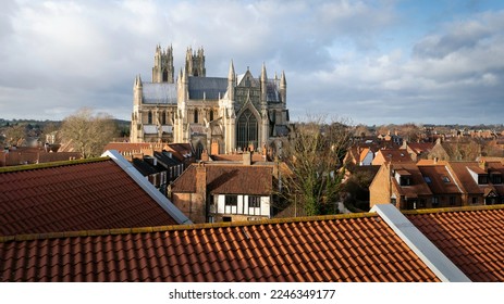 View across tiled roof-tops towards the ancient 12th Century minster under a bright clouded sky in winter in Beverley, Yorkshire, UK. - Shutterstock ID 2246349177