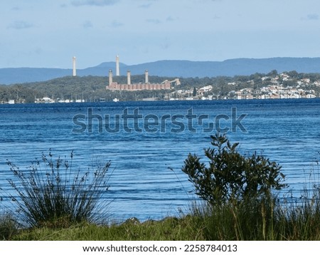 View across the waters of Lake Macquarie from the shore to the Wangi Wangi Power Station near Swansea New South Wales Australia