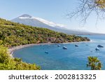 View of Agung volcano from the ocean. Villages, houses, traditional fishing boats jukung around. Amed, Karangasem Regency, Bali, Indonesia