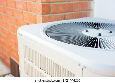 A View Of An Air Conditioner Condenser Unit In The Backyard Of A Home.