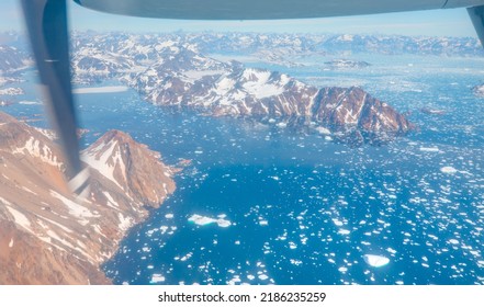 View From Airplane Of Melting Polar Ice Cap And Snowy Mountains - Greenland