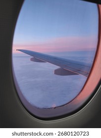 View from the airplane window. Beautiful cloudscape with sunset. Wonderful panorama above white clouds as seen through window of an plane.