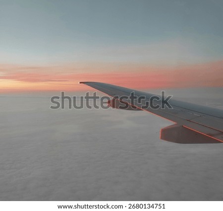 View from the airplane window. Beautiful cloudscape with sunset. Wonderful panorama above white clouds as seen through window of an plane.