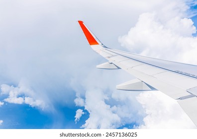 View from the airplane window at a beautiful cloudy sky and the airplane wing. Earth and sky as seen through window of an airplane. - Powered by Shutterstock