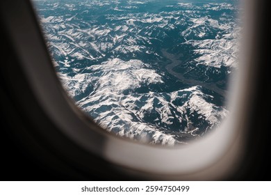 View from an airplane window, mountain range visible from plane