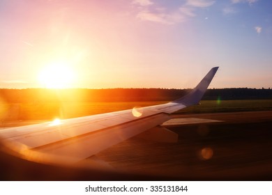 View From The Airplane Window On A Runway Before Take Off. Beautiful Sunset Or Sunrise View.