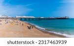 A view along the beach towards the pier in Brighton, UK in summertime