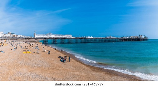 A view along the beach towards the pier in Brighton, UK in summertime
