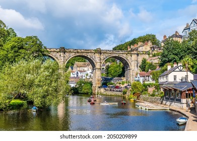 A view along the River Nidd towards the viaduct in the town of Knaresborough in Yorkshire, UK in summertime - Shutterstock ID 2050209899