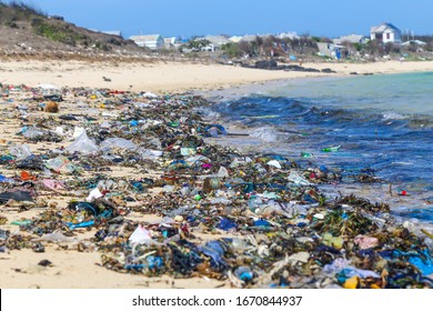 A view along a sandy beach full of plastic garbage. Ecological problem of garbage in the oceans